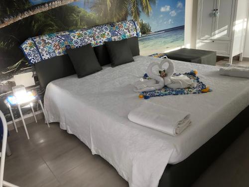 1 dormitorio con 1 cama con toallas y animales de peluche en MARINA BAY, en Terrasini