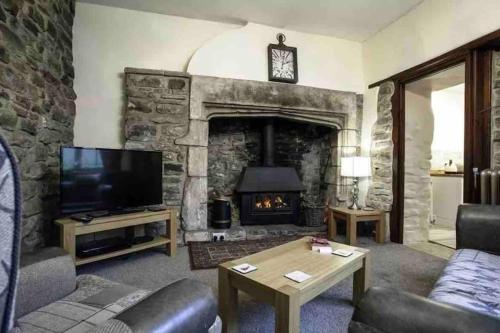 a living room with a stone fireplace and a tv at Medieval 5 Bedroom House in Stanhope Old Hall in Stanhope