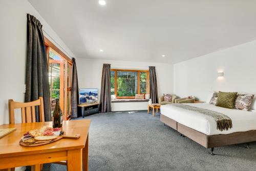 una camera con letto, tavolo e scrivania di Harrogate Gardens Motel a Hanmer Springs