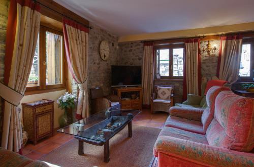 a living room with a couch and a coffee table at Apartahotel Faure in Sallent de Gállego