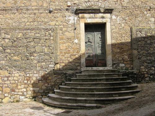 a stone building with stairs leading to a door at Il Castello in Petralia Sottana