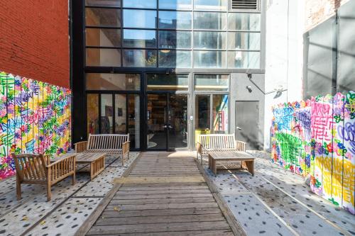 a group of benches in front of a building with graffiti at Orchard Street Hotel in New York