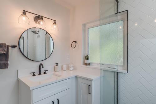 Baño blanco con lavabo y espejo en Luxury Tiny Home 2 Miles from Downtown Orlando en Orlando