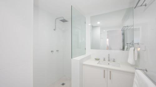 une salle de bain blanche avec lavabo et douche dans l'établissement Talinga 4, à Yamba