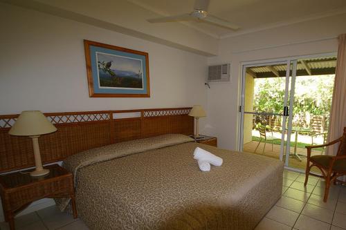 a bedroom with a bed with a white towel on it at Port Douglas Plantation Resort in Port Douglas