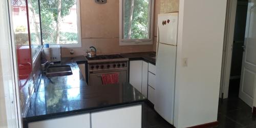 cocina con refrigerador blanca y fregadero en Villa Paz & Tranquilidad en Sierra de los Padres