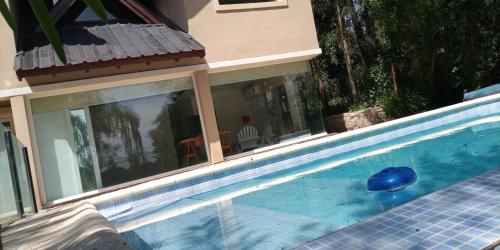 una piscina con una bola azul frente a una casa en Villa Paz & Tranquilidad en Sierra de los Padres