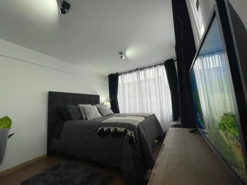 1 dormitorio con cama y ventana grande en Loft valle escondido, en Concepción