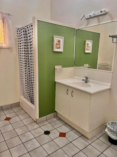 a bathroom with a sink and a mirror at Colonial Village Resort in Hervey Bay