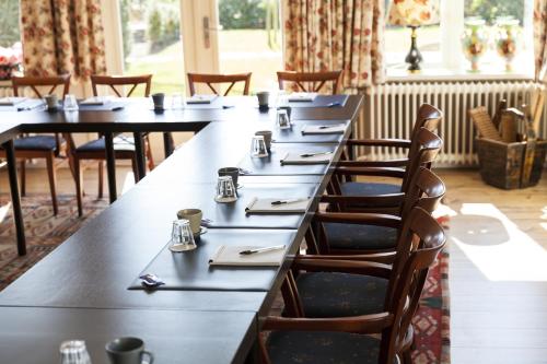 a row of tables in a restaurant with chairs at Hotel Vierhouten in Vierhouten