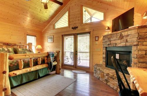 a living room with a fireplace in a log cabin at Astounding River View in Copperhill