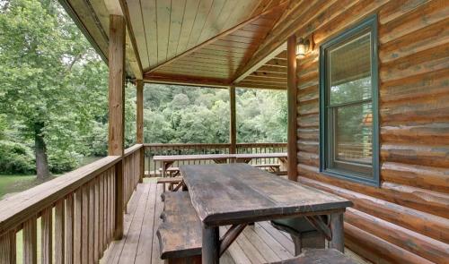 a wooden porch with a wooden picnic table on it at Astounding River View in Copperhill