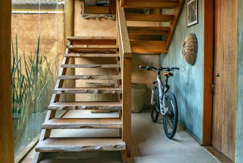 a wooden staircase in a room with a bike at Casa da Arquiteta Guest House in Ilhabela