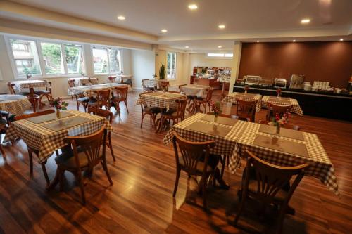 a restaurant with tables and chairs in a room at Hotel Querência in Gramado