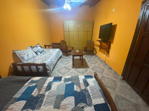 1 dormitorio con 1 cama y TV. en Cabaña Emilia en San Javier