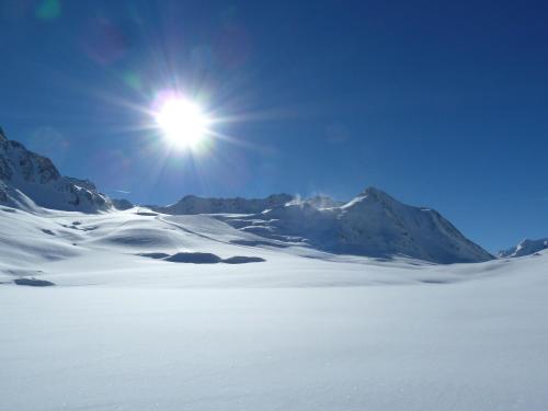 a sun shining over a snow covered mountain at Glacier Hotel Grawand in Maso Corto