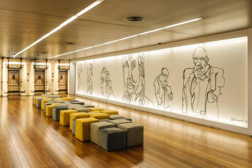 a row ofools in a room with drawings on the wall at Holiday Inn Porto Gaia, an IHG Hotel in Vila Nova de Gaia