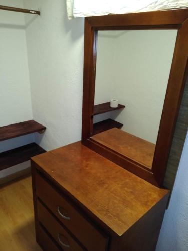 a mirror sitting on top of a wooden dresser at Finca Mc'Clau Teotihuacan, Casa residencial entera in San Martín de las Pirámides