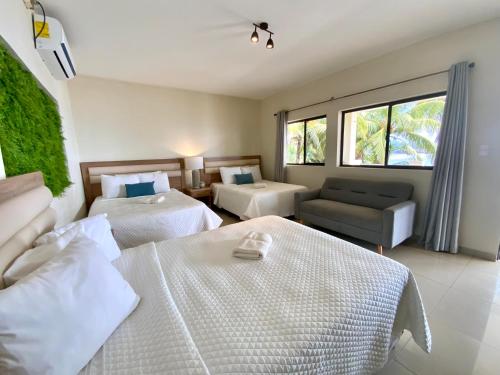 a hotel room with two beds and a couch at Paradise Surf Hotel in San Miguel