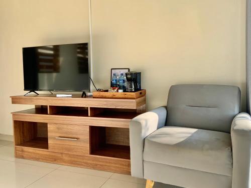 a living room with a chair and a television at Paradise Surf Hotel in San Miguel