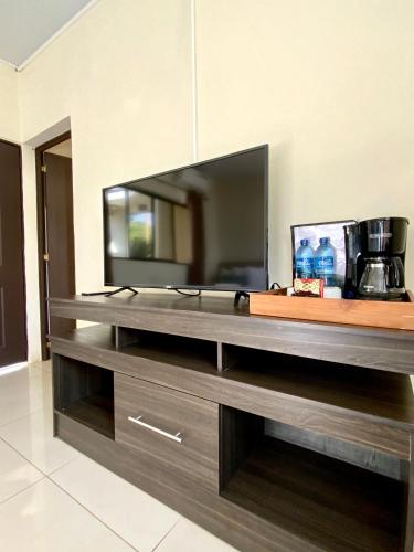 a large entertainment center with a large flat screen tv at Paradise Surf Hotel in San Miguel
