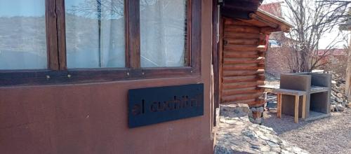 Una puerta a una cabaña con un cartel. en WAIKIRI en Potrerillos