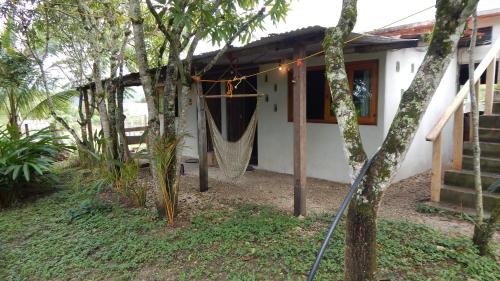 a house with a hammock outside of it at Casita Tonina in Ocosingo