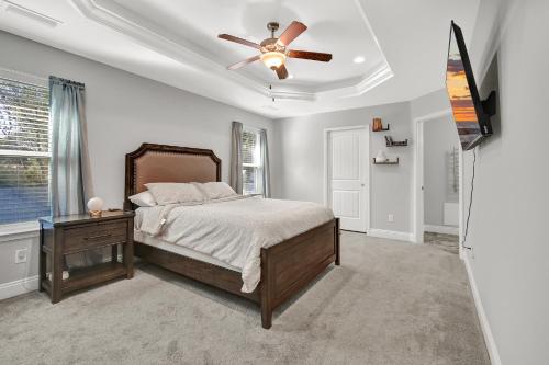a bedroom with a bed and a ceiling fan at Nice 4-Bedroom home 15 mins from the beach in Navarre
