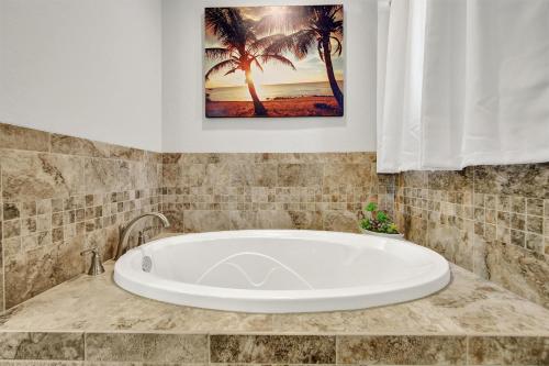 a bath tub in a bathroom with palm trees at Nice 4-Bedroom home 15 mins from the beach in Navarre