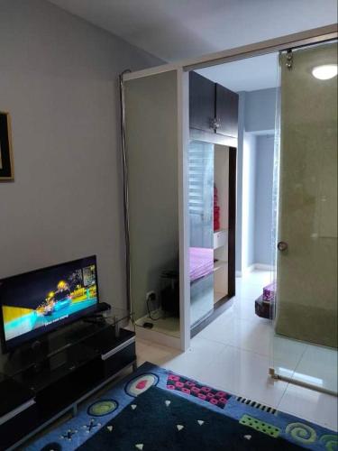 ein Wohnzimmer mit einem Flachbild-TV und einem Spiegel in der Unterkunft Taal Haven at SMDC Wind Residences Tagaytay in Tagaytay