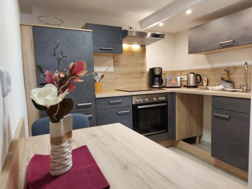 a kitchen with a table with a vase of flowers at Summerwind-Apartment in Grünberg