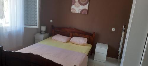 a bedroom with a bed with two pink pillows on it at Pakovo Apartments Andrija in Tivat