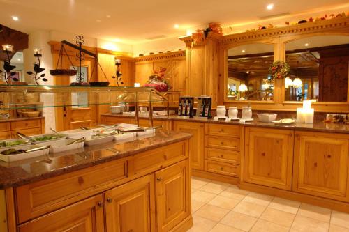 a large kitchen with wooden cabinets and counters at Hotel Bergkristall in Silbertal