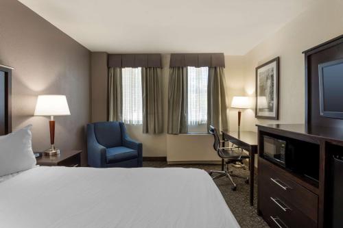 a hotel room with a bed and a chair and a television at Best Western Gregory Hotel in Brooklyn