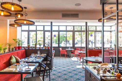 un restaurante con mesas, sillas y ventanas en Best Western Plus Hotel de Dieppe 1880 en Ruan