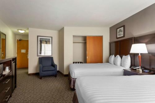 a hotel room with two beds and a blue chair at Best Western Gregory Hotel in Brooklyn