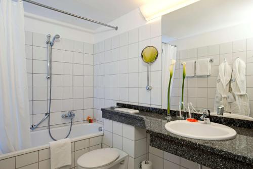 uma casa de banho com um WC, um lavatório e uma banheira em NH Hirschberg Heidelberg em Hirschberg an der Bergstraße