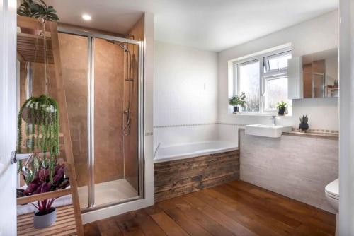 een badkamer met een douche, een bad en een wastafel bij Scar View - Getaway for Two in Underbarrow