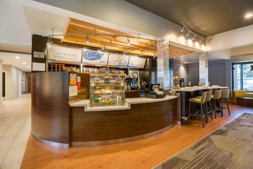 a bar in a restaurant with a counter at Sonesta Select Huntington Beach Fountain Valley in Huntington Beach