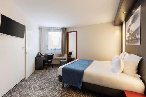 una camera d'albergo con letto e scrivania di Best Western St Exupery Bordeaux Ouest a Eysines