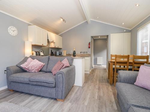 a living room with a couch and a kitchen at Wansfell Lodge in Windermere
