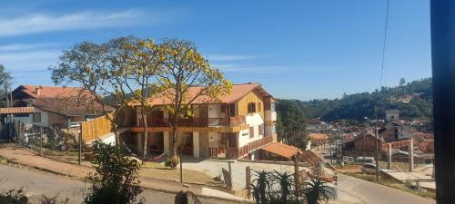 uma casa com varanda ao lado de uma rua em Recanto das Glicínias em Monte Verde