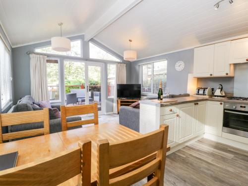 a kitchen and living room with a table and a couch at Wansfell Lodge in Windermere