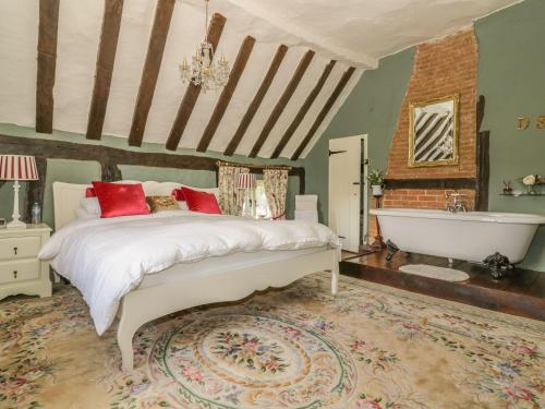 a bedroom with a bed and a bath tub at Waveney Cottage in Diss
