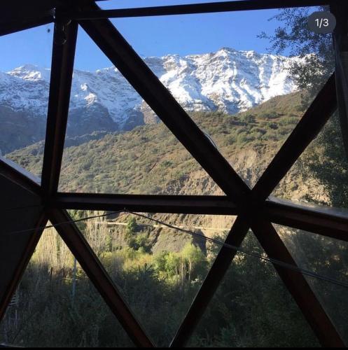 a view of a snow covered mountain from a window at Cabaña El Ingenio in El Ingenio