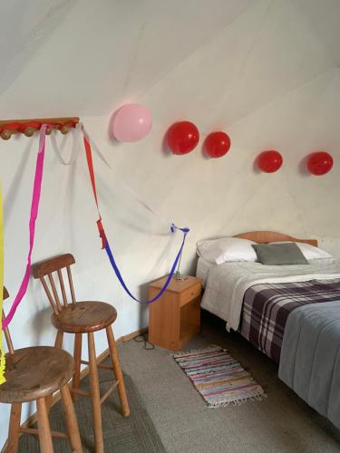 a bedroom with a bed and two chairs and red lights at Cabaña El Ingenio in El Ingenio