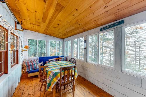 a dining room with a table and chairs and windows at The Red Camp in Casco