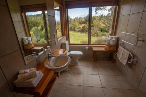 a bathroom with a sink and a toilet and a window at Paramata Lodge in Kakapotahi