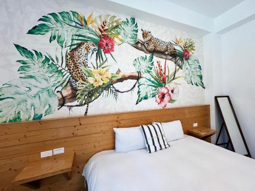 a bedroom with a bed with a painting on the wall at Kenting Peninsula Inn in Kenting
