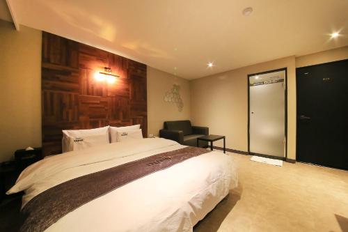 a bedroom with a large bed and a chair at DUNE45 in Suwon